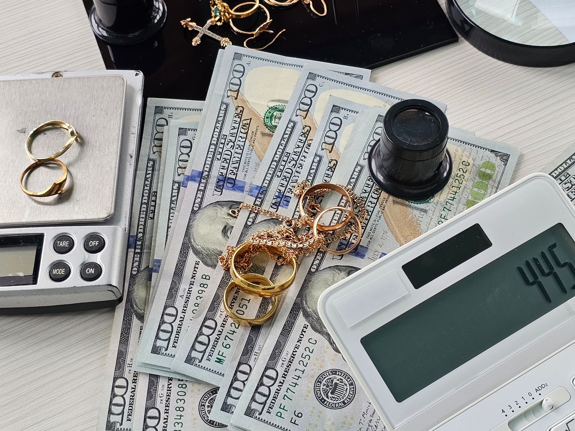 Jewelry and cash laid out on a table during assessment and valuation process concept