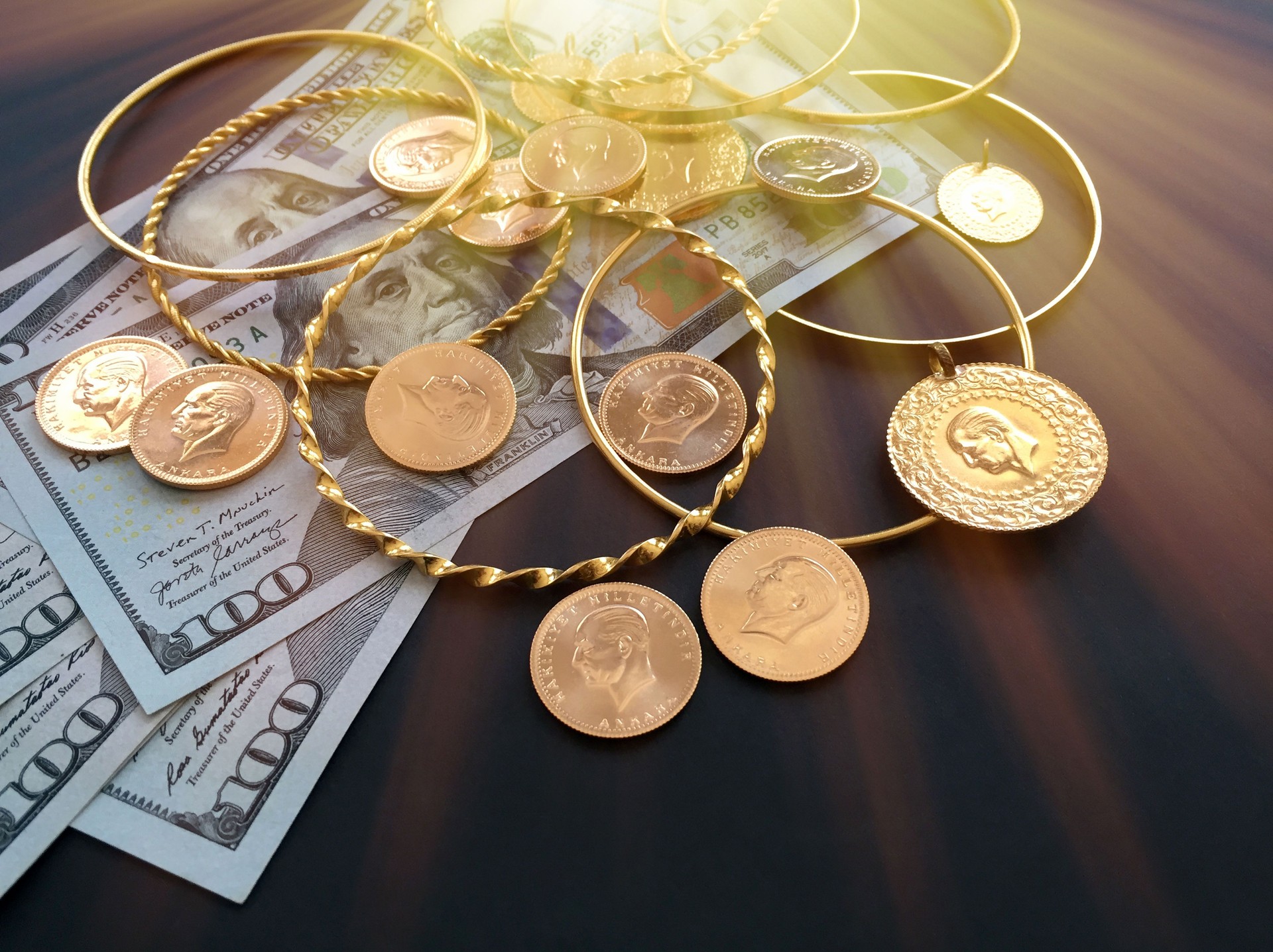 Finance and economy investment concepts. Gold coins, gold bracelets and dollars
